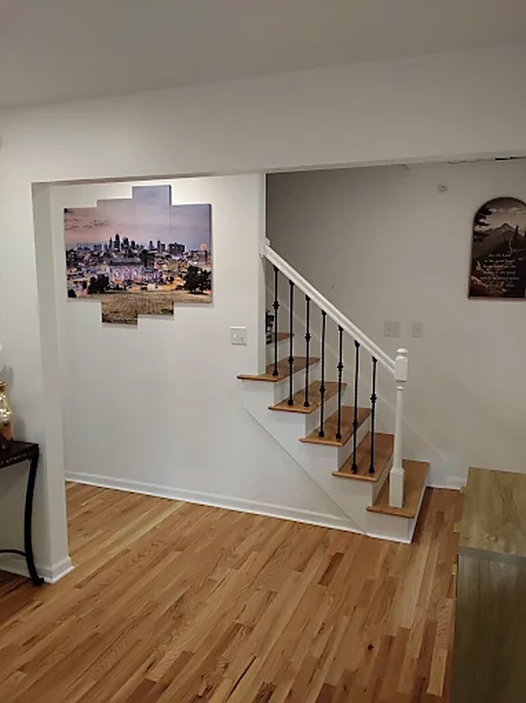 Home The open common area with hardwood floors and the staircase